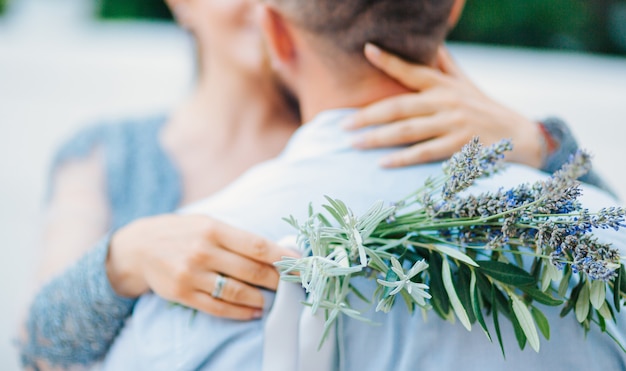 Bouquet da sposa lavanda nelle mani della sposa in abito bianco-blu