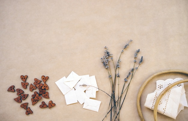 Lavender, wooden buttons, homemade envelopes, old wooden hoop and ribbons with hem on craft paper.