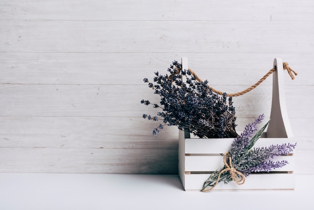 Lavenders in the white wooden crate against wooden backdrop