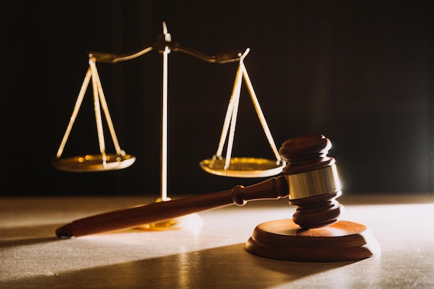 Law books and scales of justice on desk in library of law firm jurisprudence legal education concept