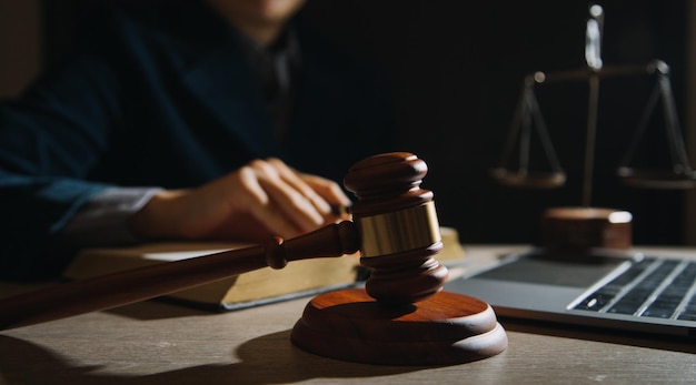 Law books and scales of justice on desk in library of law firm jurisprudence legal education concept