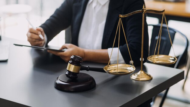 Law books and scales of justice on desk in library of law firm jurisprudence legal education concept