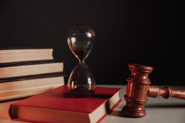 Law concept. Hourglass on book and judge gavel.