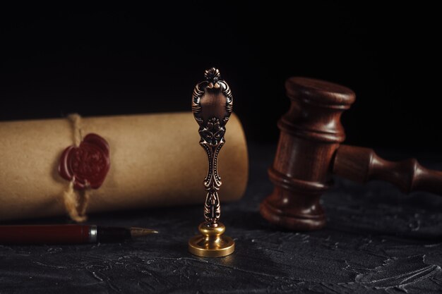 Law concept with stamp in courtroom. wooden gavel and old\
notarial wax seal