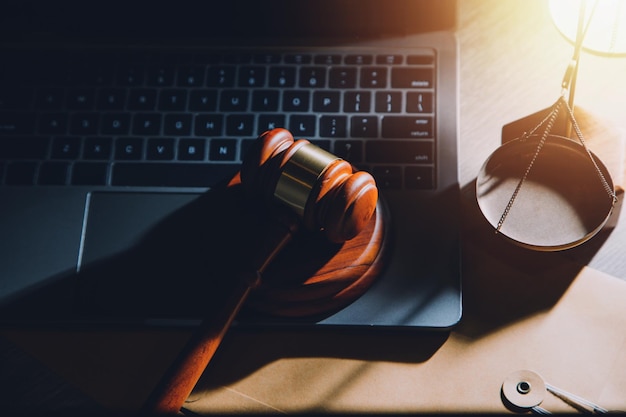 law legal technology concept judge gavel on computer with scales of justice on desk of lawyer