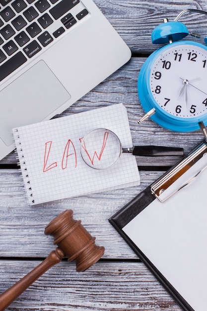 Photo law and time concept. laptop with clipboard and gavel on white wooden table.