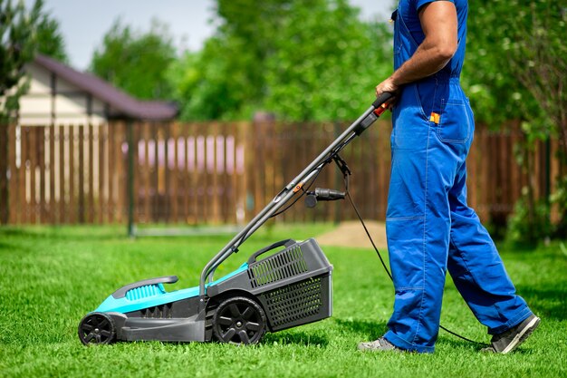 lawn grass mowing. worker cutting grass in a green yard