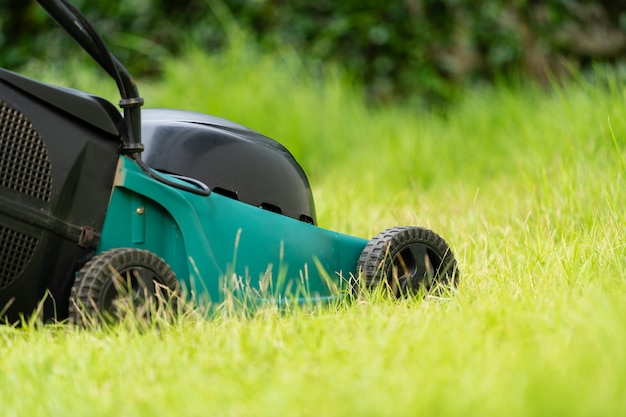 Lawn mower on the green grass at home