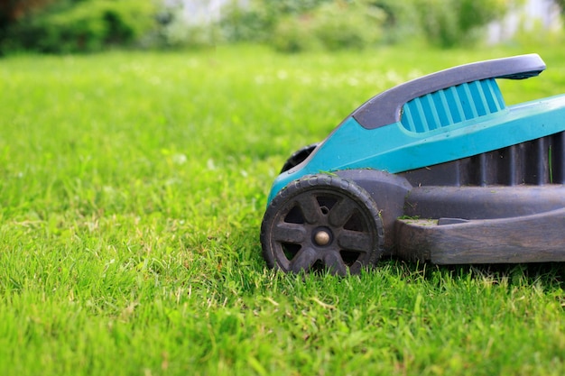 Lawn mower on a green lawn in the garden