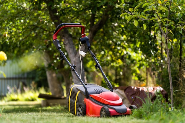 Lawn mower on a lawn in the garden gardening Landscape terrain at backyard Special equipment for landscape terrain Gardening concept Closeup