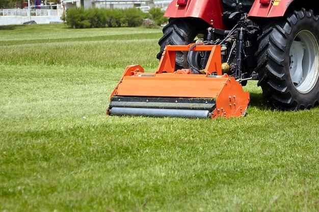 Photo lawn mower tractor mows green grass