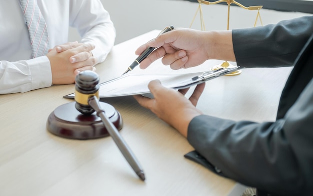 Lawyer hand holding pen and providing legal consult business dispute service at the office