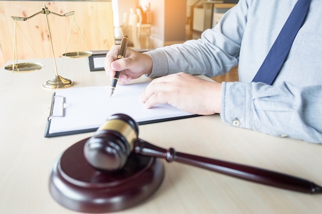 Photo lawyer hand writes the document in court (justice, law)