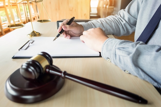 Photo lawyer hand writes the document in court (justice, law)