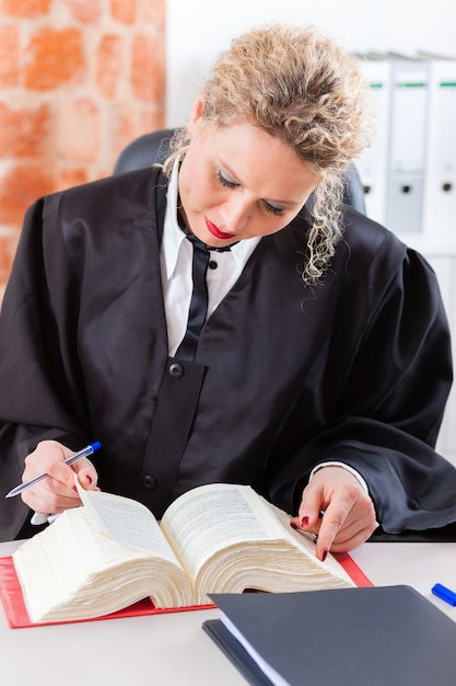 Lawyer in office reading law book