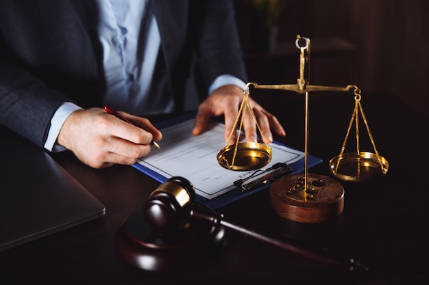 Lawyer office. Statue of Justice with scales and lawyer working on a laptop