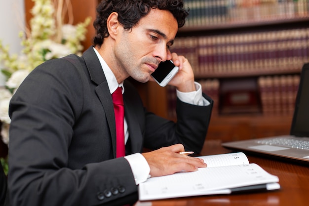 Lawyer reading a book and talking at the phone