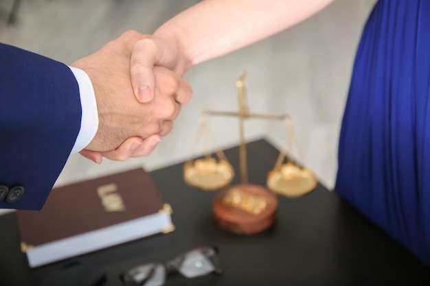 写真 オフィスのクローズアップでクライアントと握手する弁護士