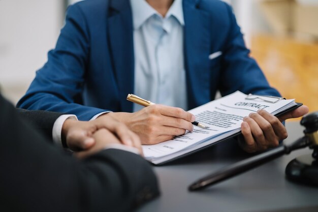 Lawyer signing important legal document on desk at office