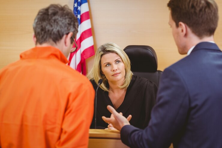Photo lawyer speaking about the criminal in orange jumpsuit