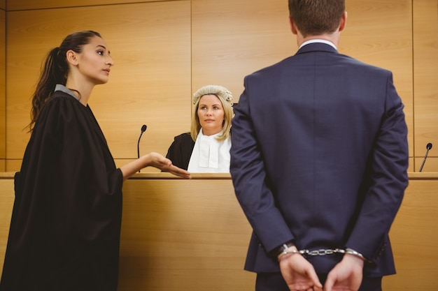 Photo lawyer talking with the criminal in handcuffs