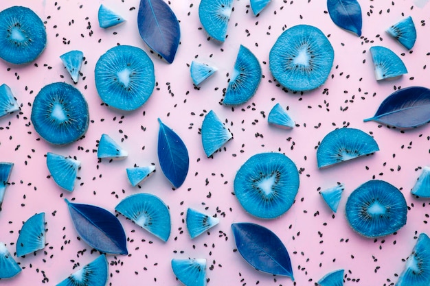 Lay flat sliced blue kiwi with seeds on solid pink background summer concept