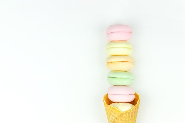 Lay-out met wafel kegel cornet en gekleurde marshmallows ziet eruit als bitterkoekjes op witte achtergrond