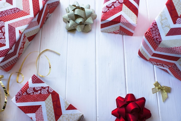 Lay-out van geschenken in wit en rood papier op de achtergrond van een witte houten tafel