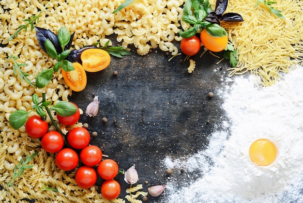 Lay-out van pasta en groenten op een donkere muur