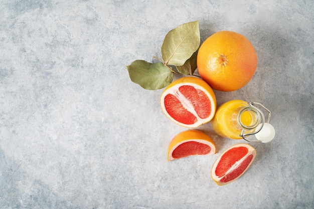 Lay-out van sappige rode grapefruits en sap in een fles op een blauwe achtergrond Concept gezond en dieetvoedsel Bovenaanzicht en kopieer ruimte