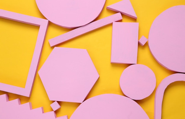 Lay-outsamenstelling van roze geometrische vormen op gele achtergrond Flat lay
