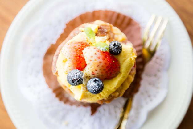 Layer Cake with Strawberry and Blueberry Topping on Yellow Cream