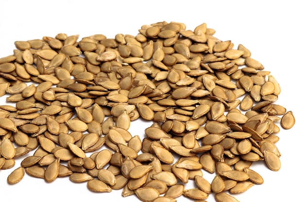 A layer of pumpkin seeds on a white background