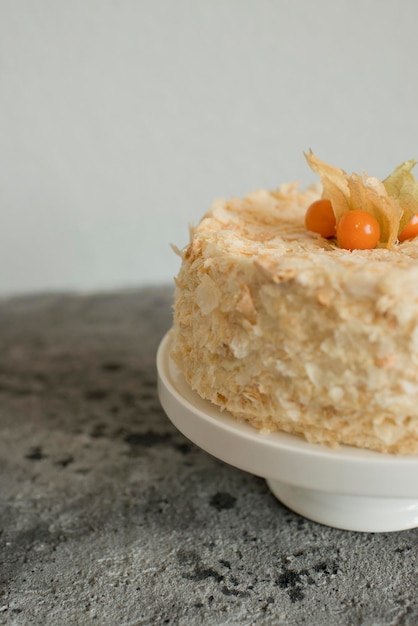 Layered cake on a plate decorated with physalis