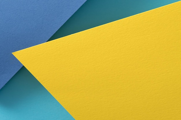 Layered construction paper background yellow and blue color abstract design with copyspace