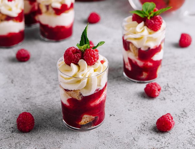 Layered dessert Trifle with vanilla cake whipped cream and fresh raspberries