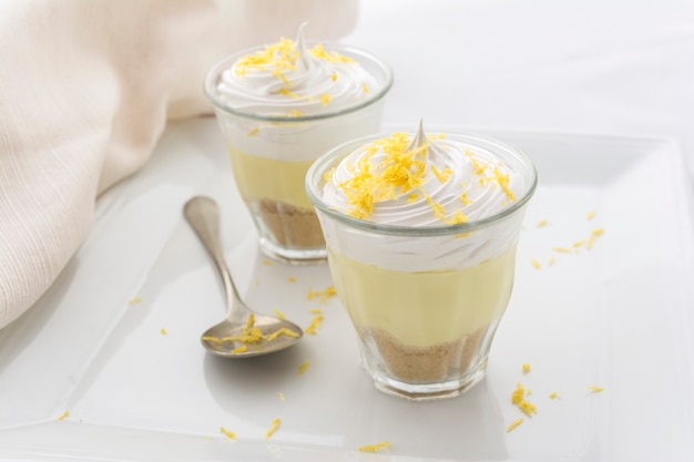 Layered dessert with lemon cream, ice cream and whipped cream