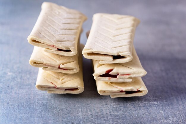 Layered of a fluffy uncooked raw buns french dough cake with
jam on blue background pastry cake