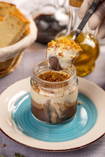 Layered mousse with crunchy crumbs topping served in glass on the restaurant table