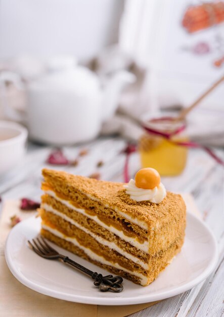 Layered orange cheesecake on plate on wooden table