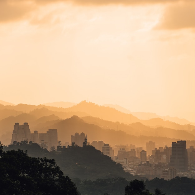 Photo layers of taipei cityscape and mountains with sunlight when the sun going down that view from xiangshan elephant mountain in the evening in taipei, taiwan.