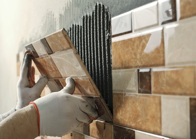 Photo laying ceramic tiles. tiler placing ceramic wall tile in position over adhesive