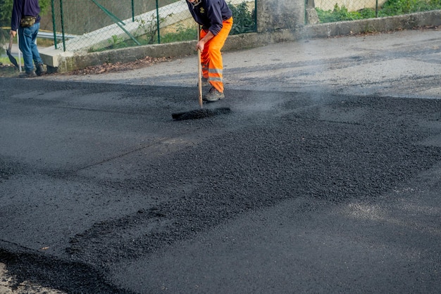 Foto posa di nuovo asfalto su strada sconnessa