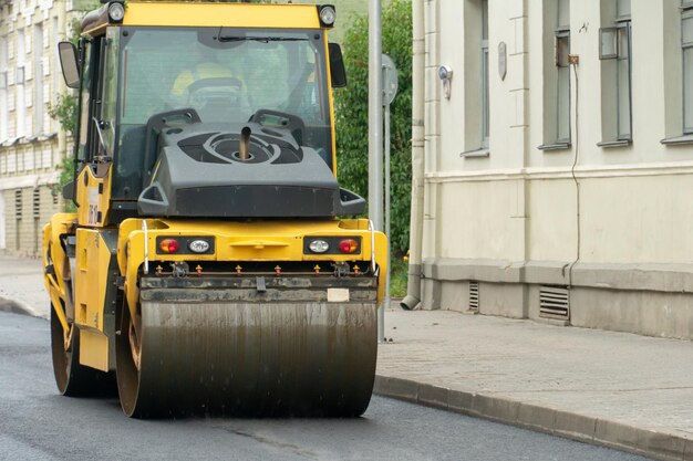 Laying of new modern asphalt asphalt laying equipment works on\
the site a yellow asphalt skating rink rides in closeup on a new\
roadbed