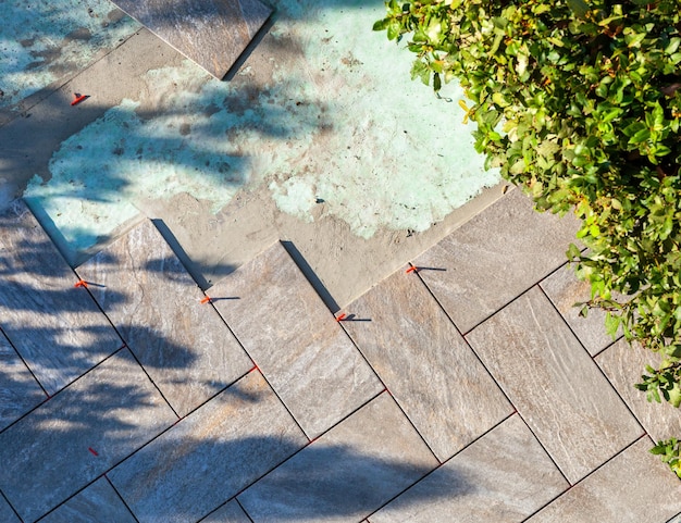 Photo laying outdoor flooring with the use of red spacers for the joints