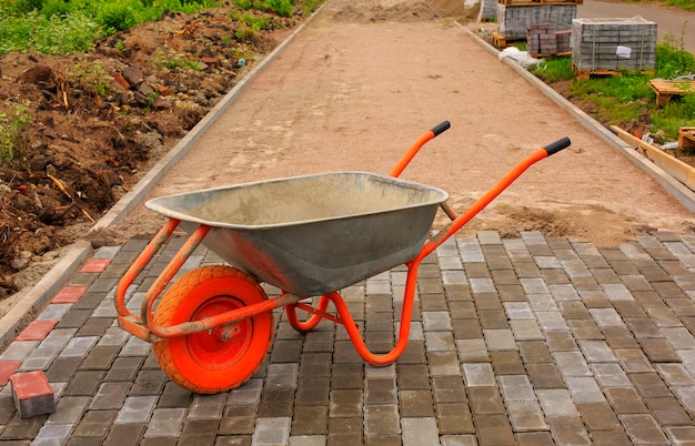 Laying of paving slabs. Repairing sidewalk. wheelbarrow.