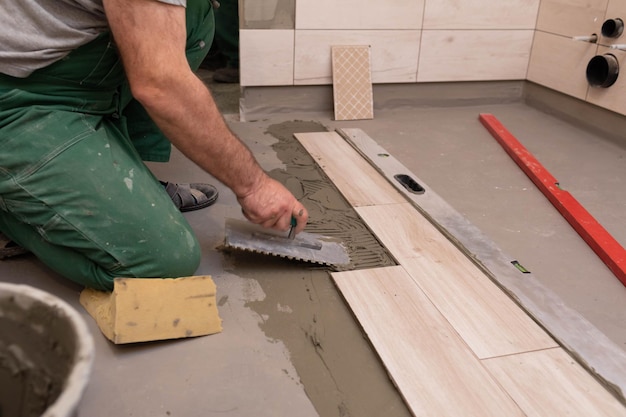 Laying terracotta in the bathroom Builder during work Adhesive for ceramic tiles