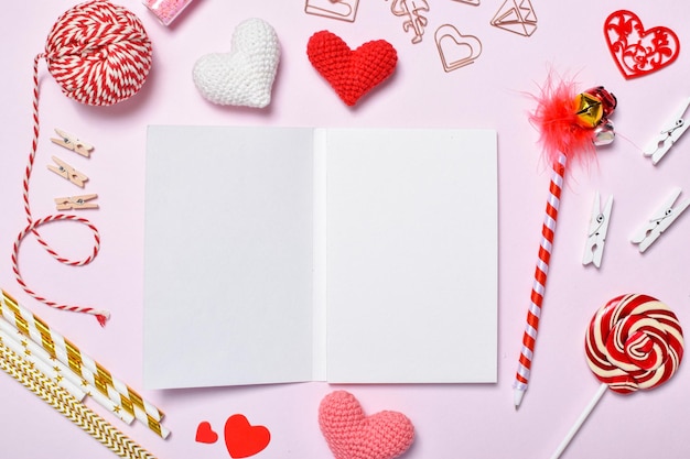 Layout of an empty notebook for a romantic meeting. Background for a copy space for Valentine's Day with gifts and knitted hearts. Copy space. Flat lay, top view.