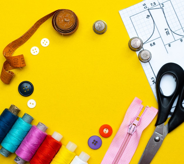 Photo layout sewing. needlework, craft, sewing and tailoring concept - box with thread spools and buttons on the table. the concept of sewing accessories. flat lay,