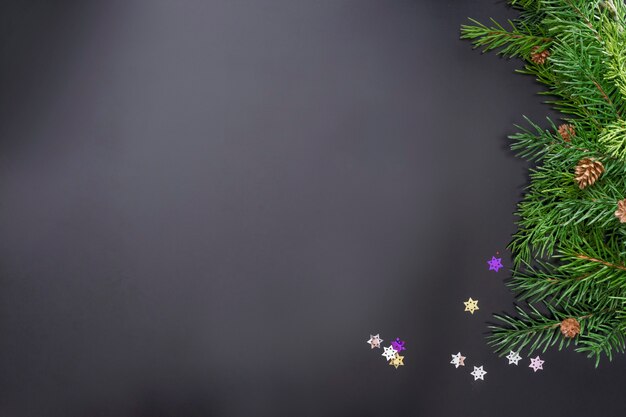 Layout on the theme of the New 2022 with toys and branches of a Christmas tree on a dark background.